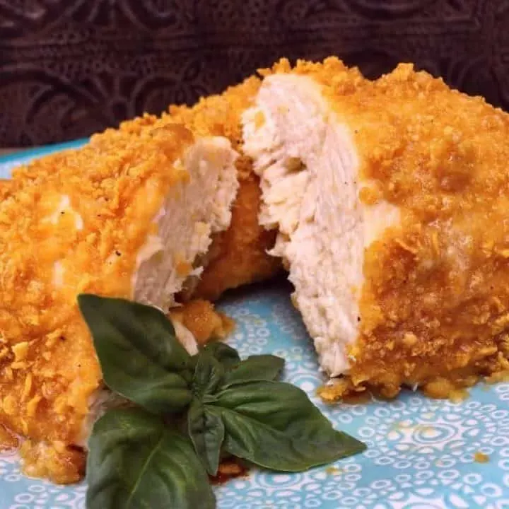 Crispy Oven Fried Parmesan Chicken on a plate cut in half.