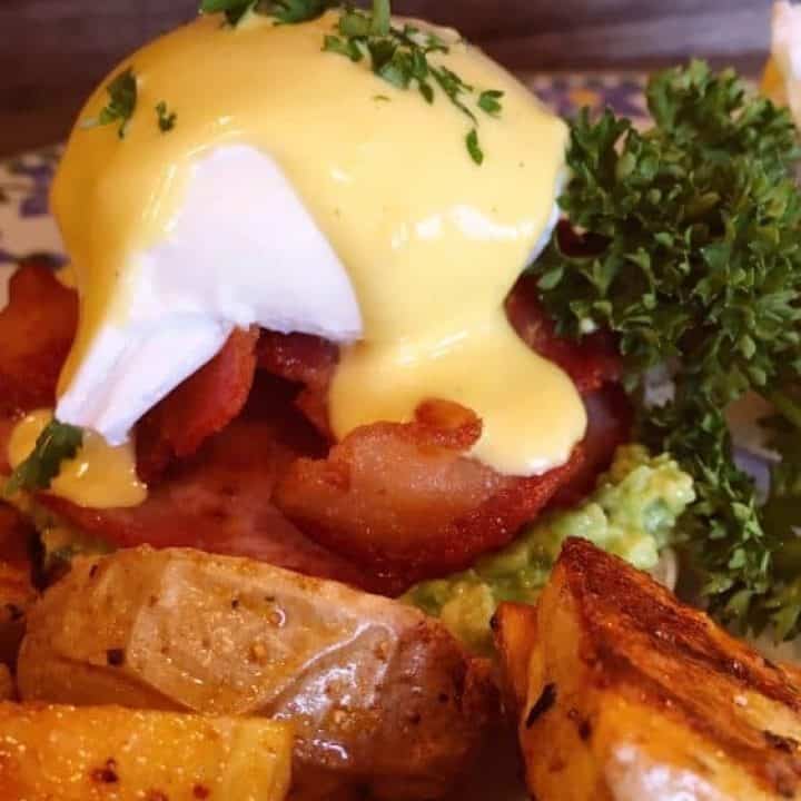 Eggs Benedict on a plate with potatoes