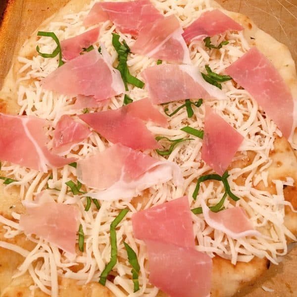 fresh basil and prosciutto on top of each pizza