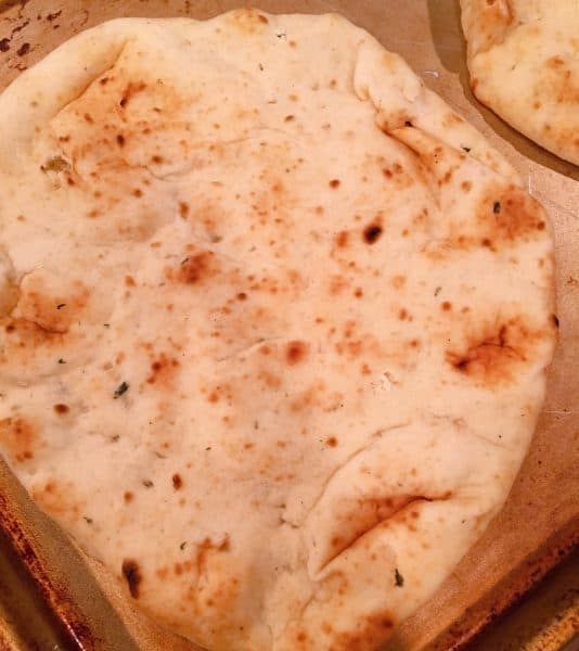 slice of naan bread on baking sheet 