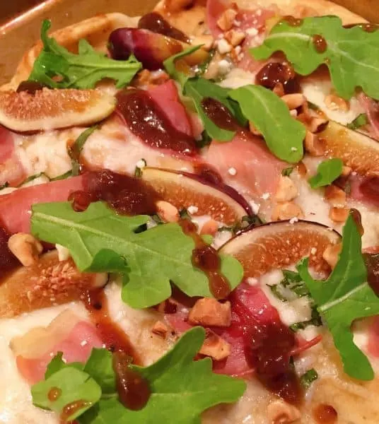 topping each pizza with arugula 