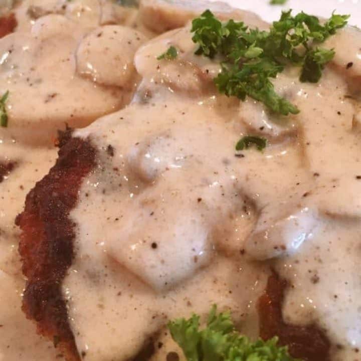 Crispy Friend Pork Chops with Creamy Mushroom Gravy on a plate