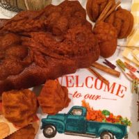 Moist Pumpkin bread loaf and muffins on a cute Fall dish towel