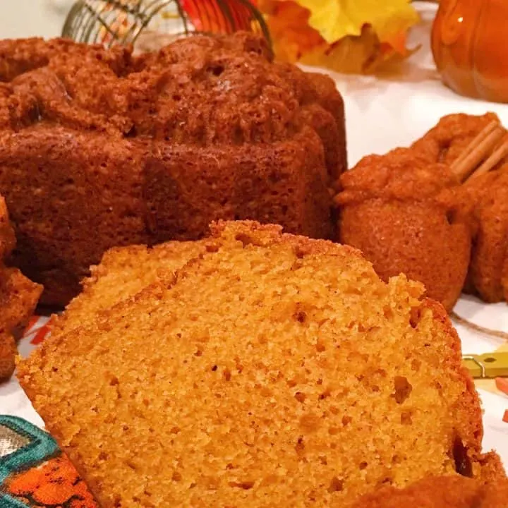 Sliced pumpkin bread and muffin on a mat
