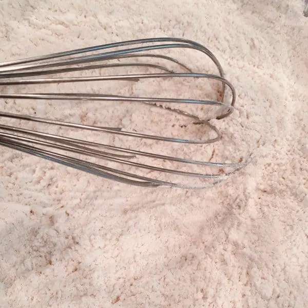 Whisking dry ingredients in large bowl, together.