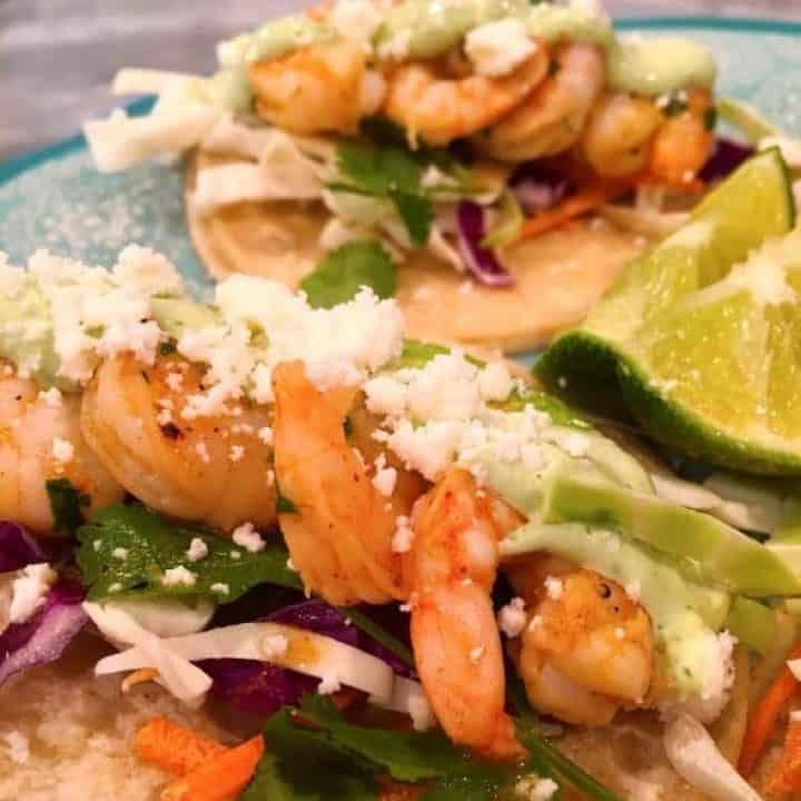 Shrimp tacos on a plate with crema sauce