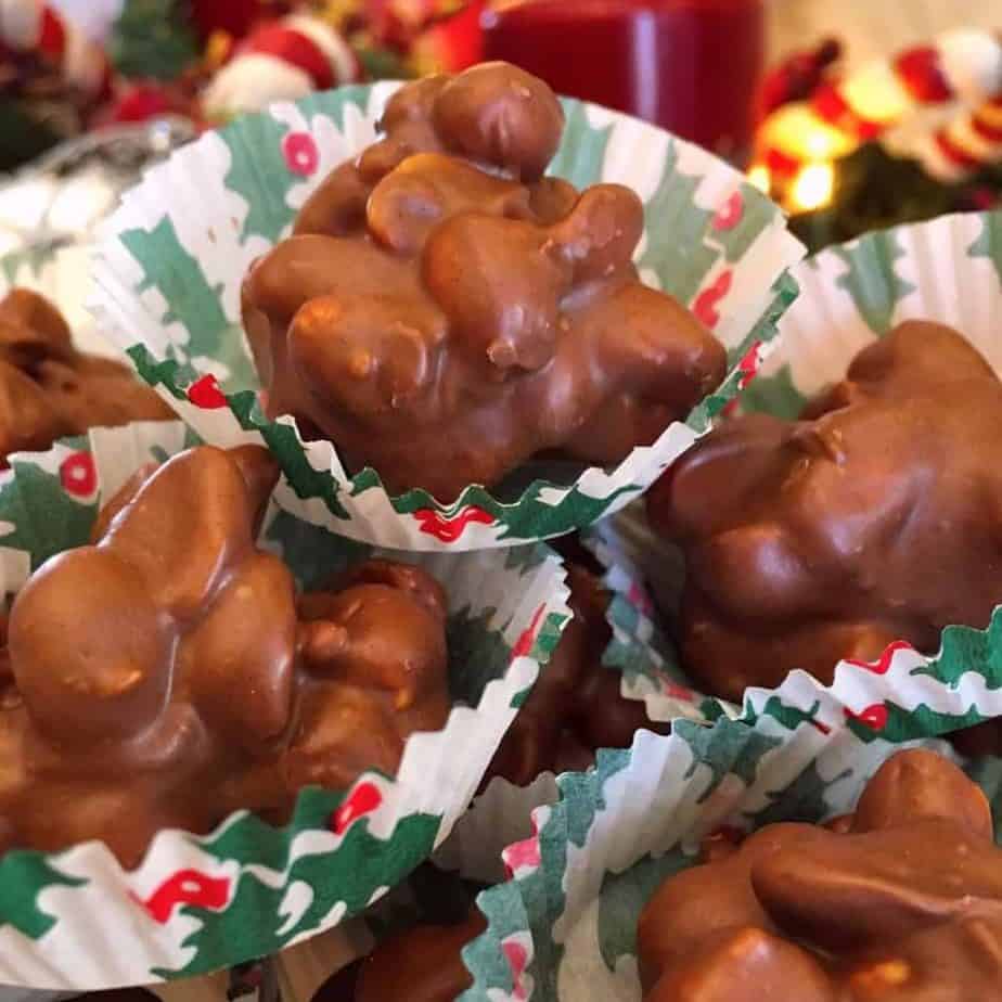 Crock pot peanut clusters in candy wrappers stacked high.