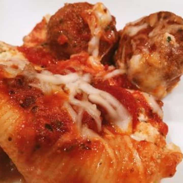 Stuffed shells topped with meatballs and sauce