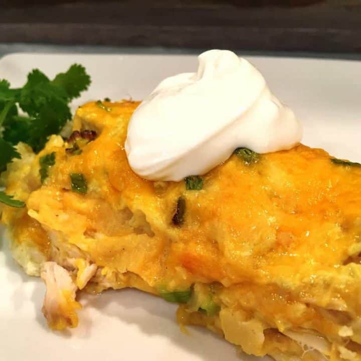 Easy White Chicken Enchilada on a plate with a dab of sour cream