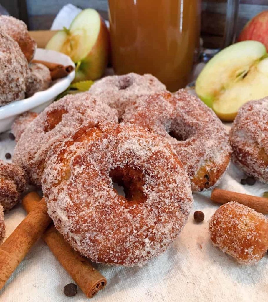 Group of Apple Cider Donuts with Apple Cider and apples