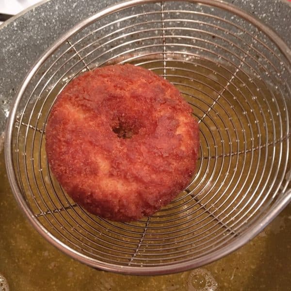 Removing cooked donut from hot oil