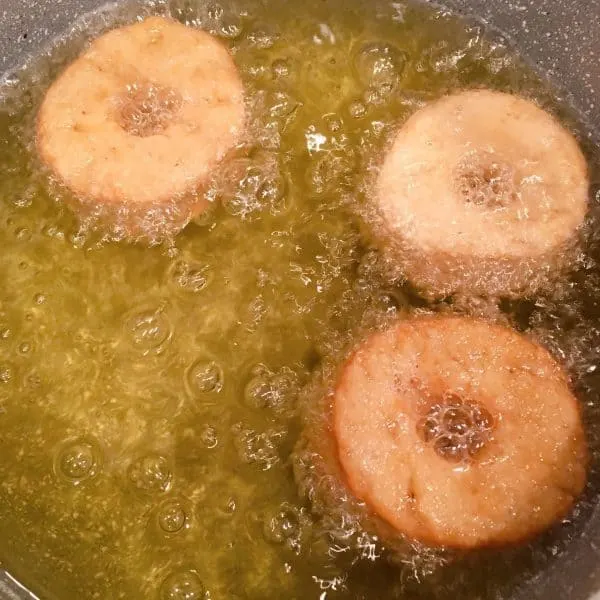 Doughnuts frying in oil.
