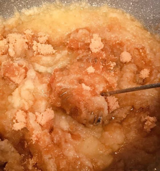 Adding sugars and water to caramel paste in sauce pan