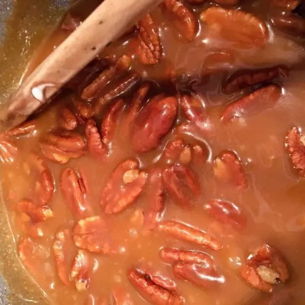 Pecan Halves being stirred into brown sugar mixture.