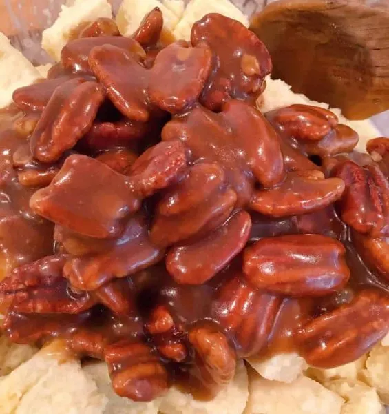 Adding pecan caramel sauce to bread pudding.