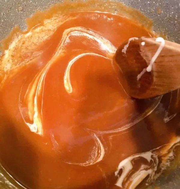 Adding cream to brown sugar and melted butter sauce.