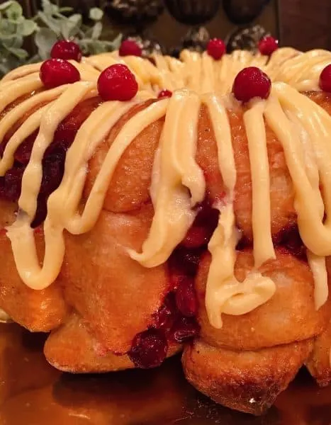 Drizzle of orange cream cheese frosting over monkey bread