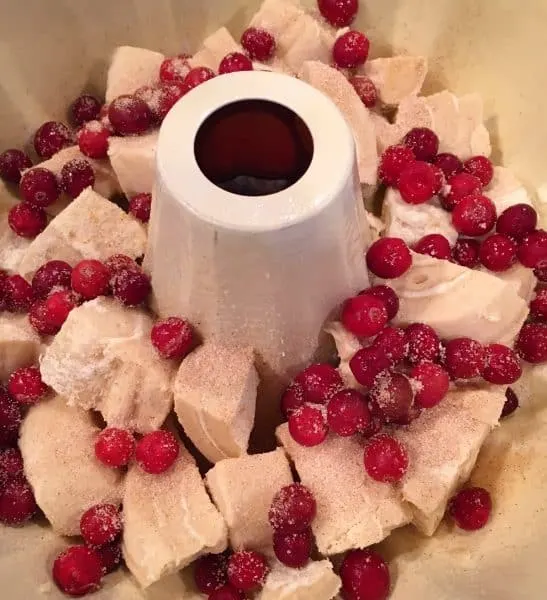 adding fresh cranberries to the cut up orange rolls