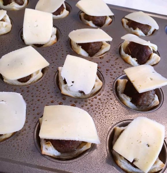 Gouda cheese slices on top of sausage balls