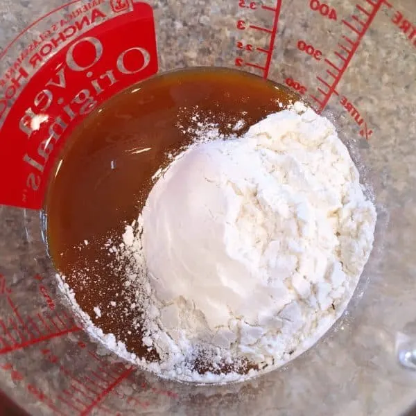Caramel sauce and flour in glass measuring cup