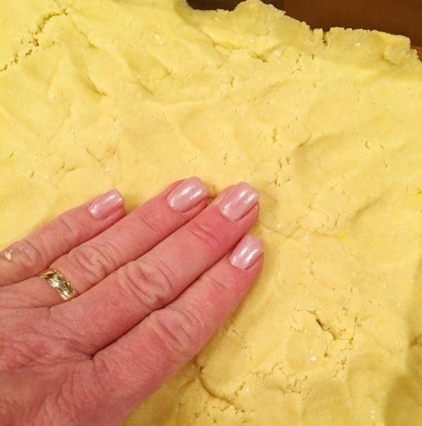 Pressing crust into the bottom of a 9 x 13 pan