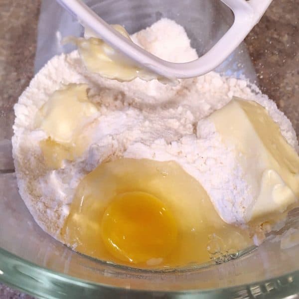cake mix, butter, and egg in the bowl of mixer
