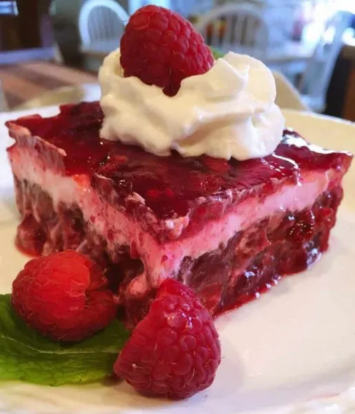 cut slice of layered raspberry jello salad