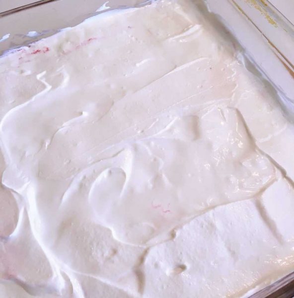spreading sour cream over jello salad layer