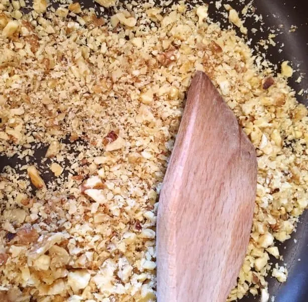 chopped walnuts being toasted in small skillet
