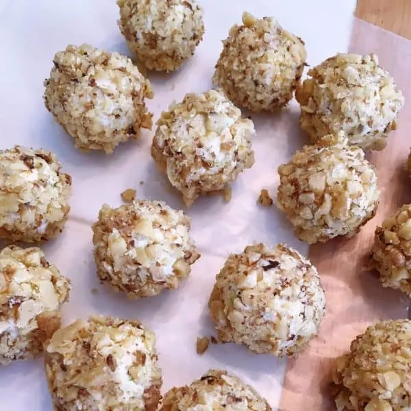 Mini blue cheese balls rolled in walnuts and laid on wax paper