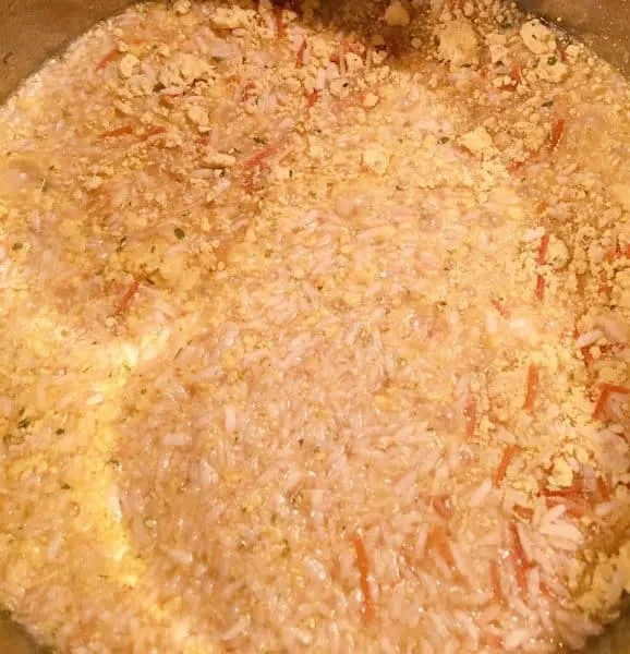 adding chicken broth to rice mixture