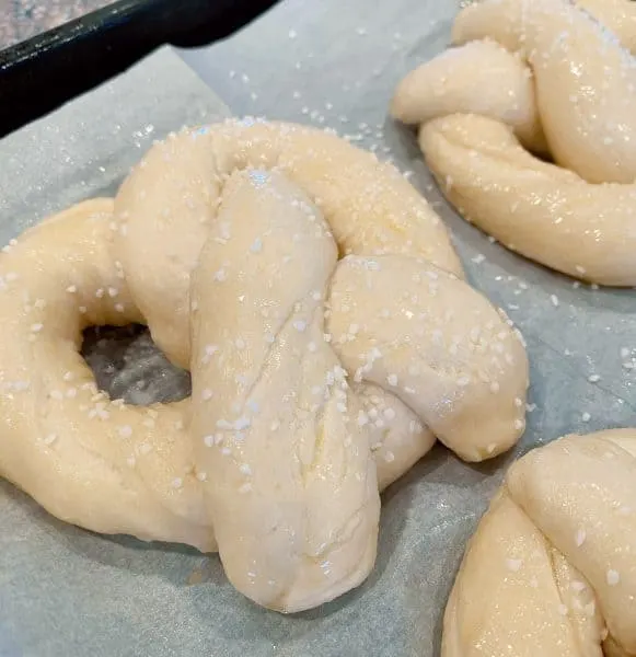 Pretzels after placed in the boiling water and brushed with egg wash and salt.