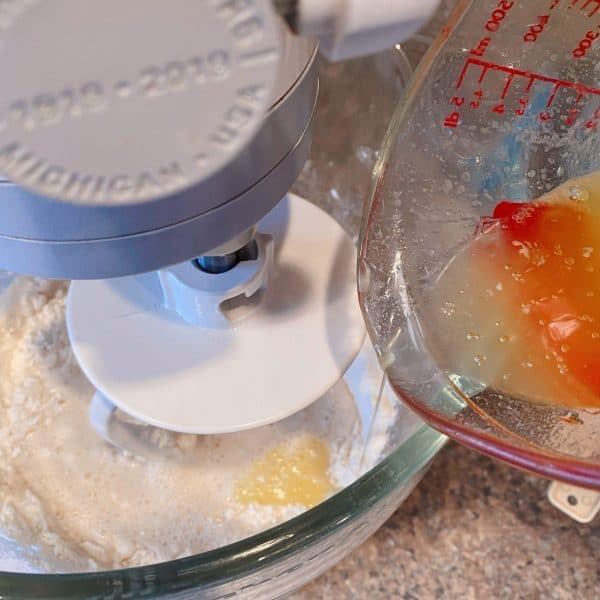 Adding flour and melted butter to the water and yeast mixture