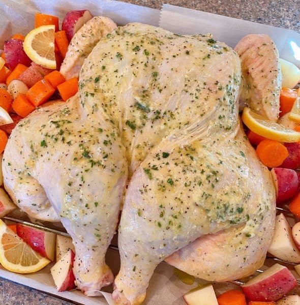 veggies placed around chicken on baking sheet