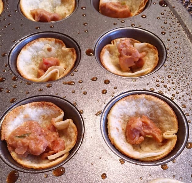 Refried beans in bottom of tostada cups