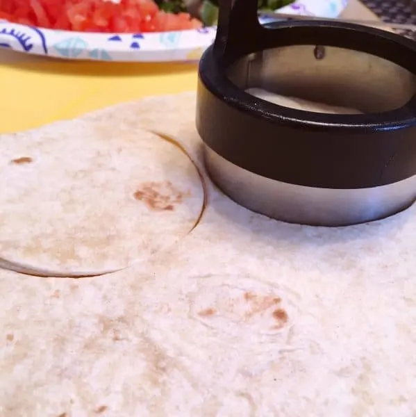 using a Biscuit cutter to cut out flour tortilla shells