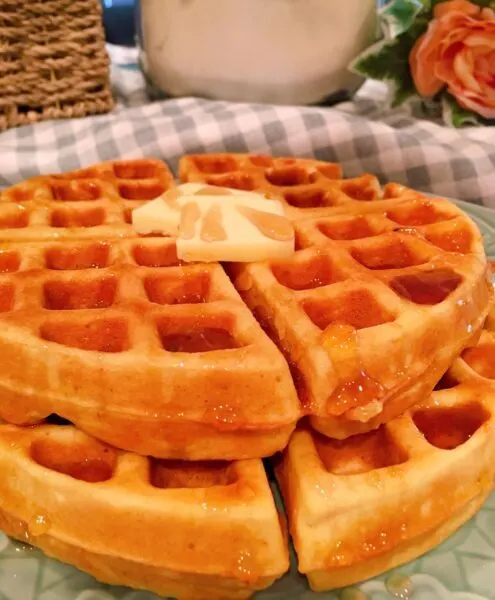 waffles stacked on a plate with butter