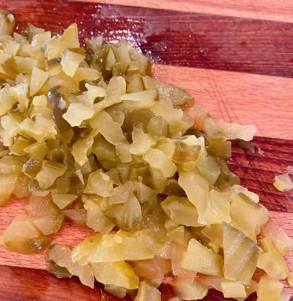 chopped dill pickles on cutting board