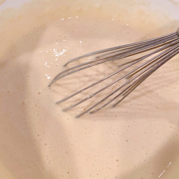 whisking ingredients to create a smooth batter
