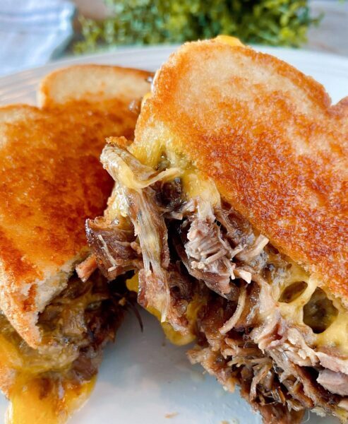 Roast beef grilled cheese sandwich cut in half and ready to eat