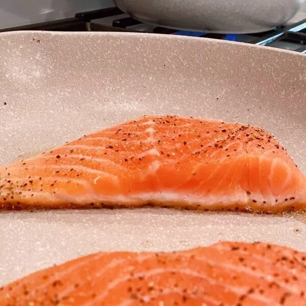 Salmon cooking in the skillet.