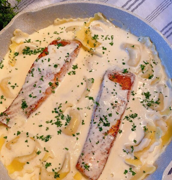 Adding salmon back into the white wine sauce with the Lobster Ravioli