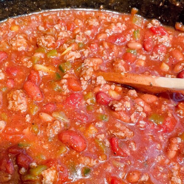 Stirring chili before slow cooking for 6-8 hours.