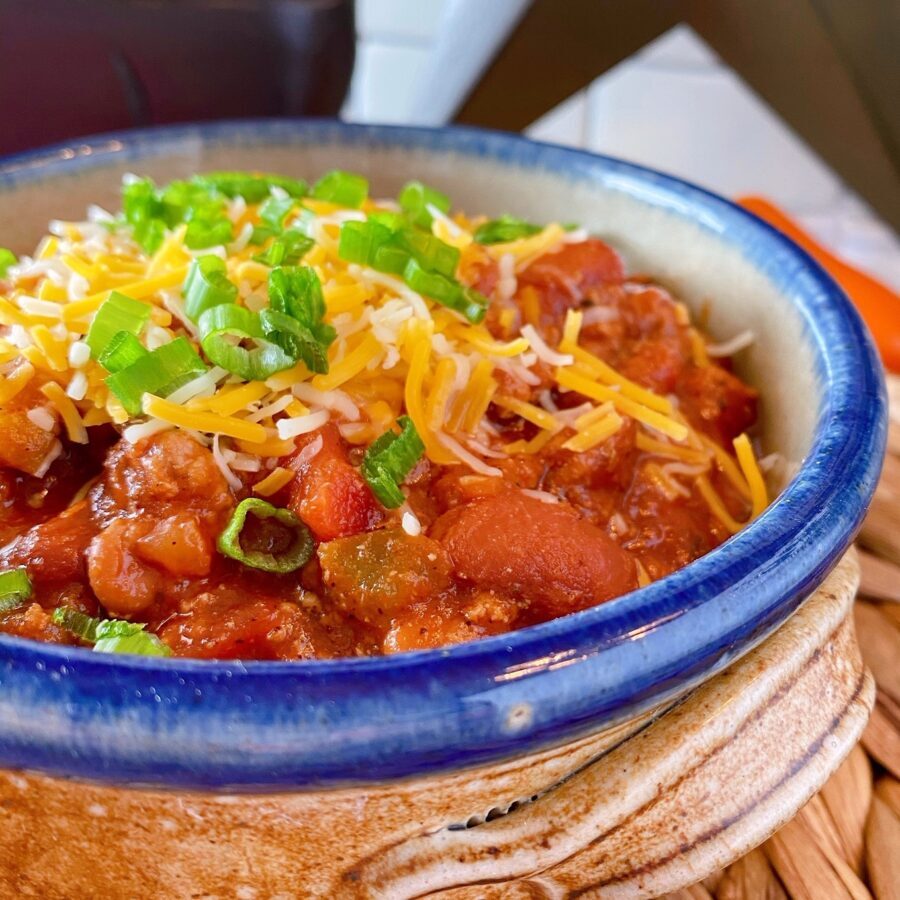 Rustic Ceramic Bowl filled with Chili and topped with cheese and green onions.