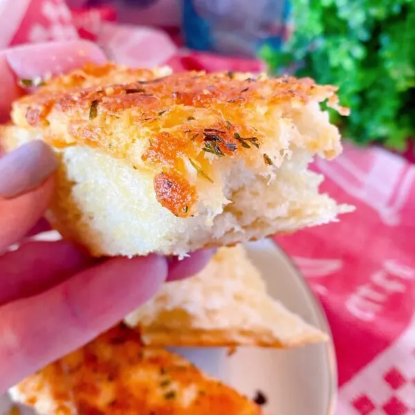 Holding a slice of bread with a bite out of it