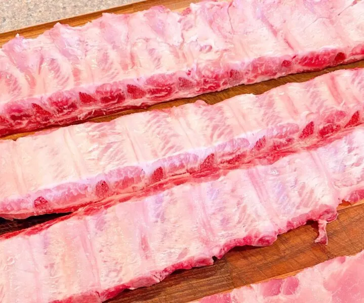 Two racks of baby back ribs cut in half lengthwise