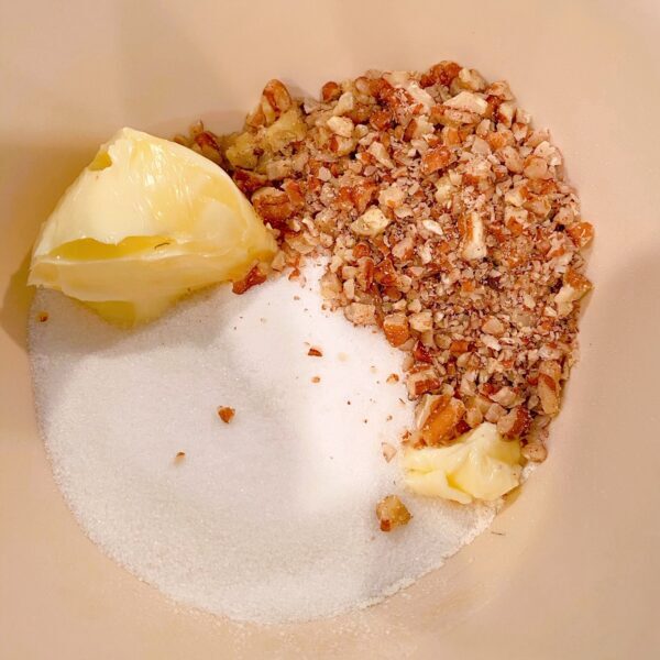 small bowl with sugar, flour, softened butter, and chopped pecans, waiting to be blended