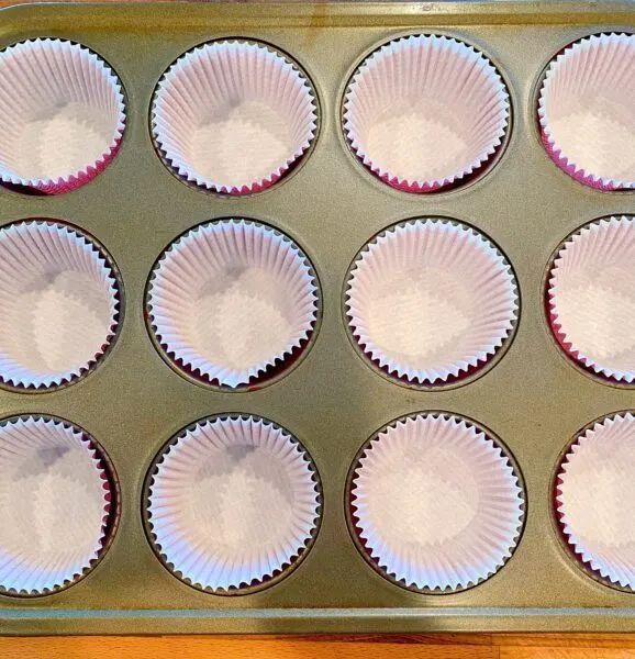 12 cup standard muffin tin lined with paper liners ready for the muffin mix.