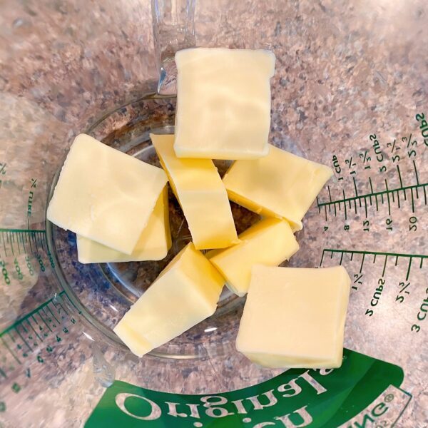 Butter cut into small cubes in a microwave safe bowl ready to melt in the microwave.