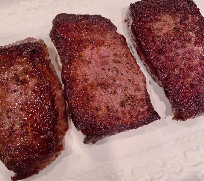 Steaks resting on platter for 5 minutes while shrimp and sauce are being prepared.